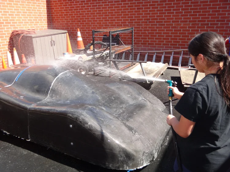 Team member washing the car body